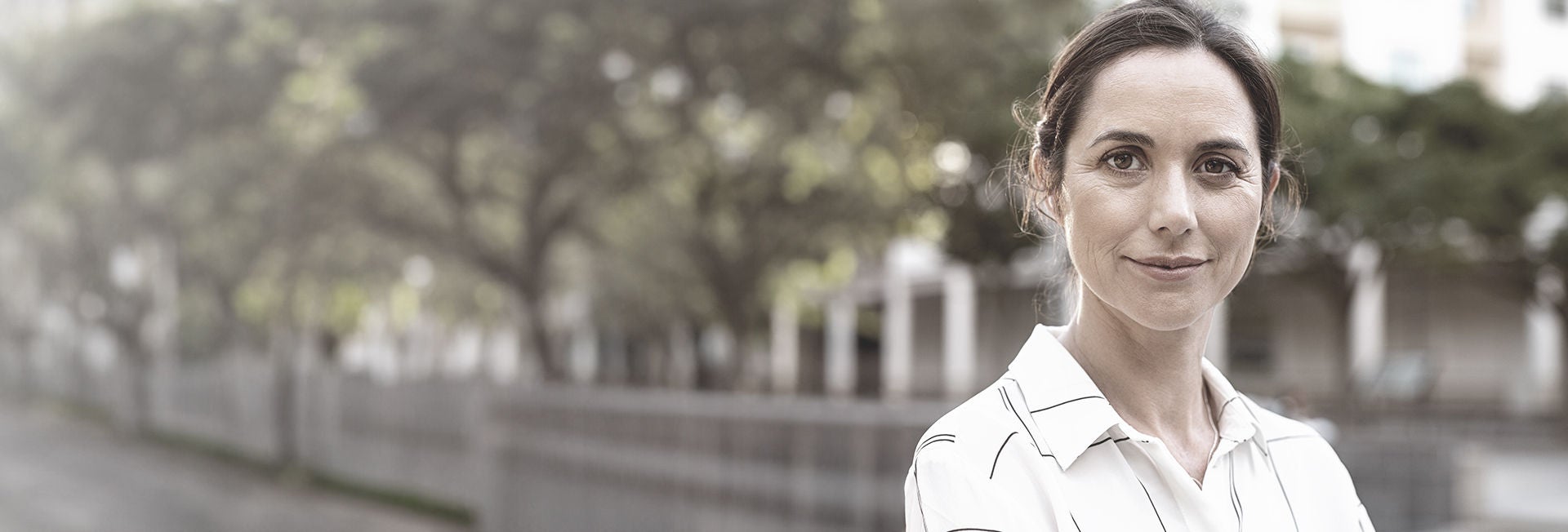 Mujer al aire libre, sonriendo con confianza