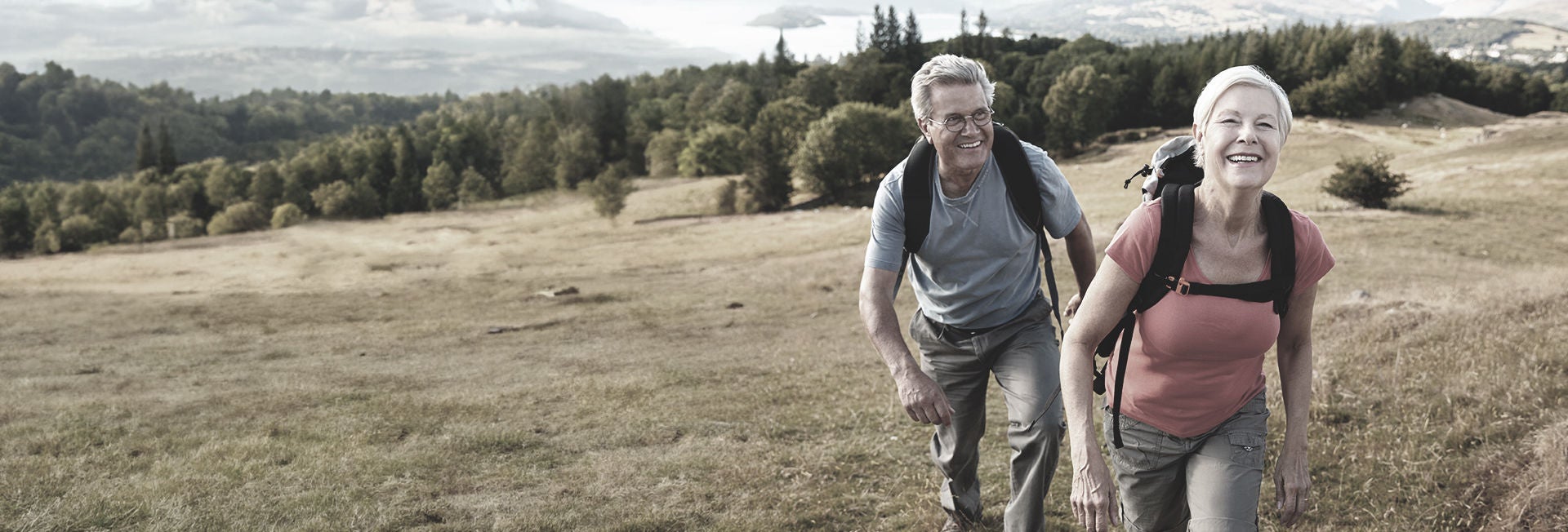 Pareja de personas mayores haciendo senderismo en plena naturaleza